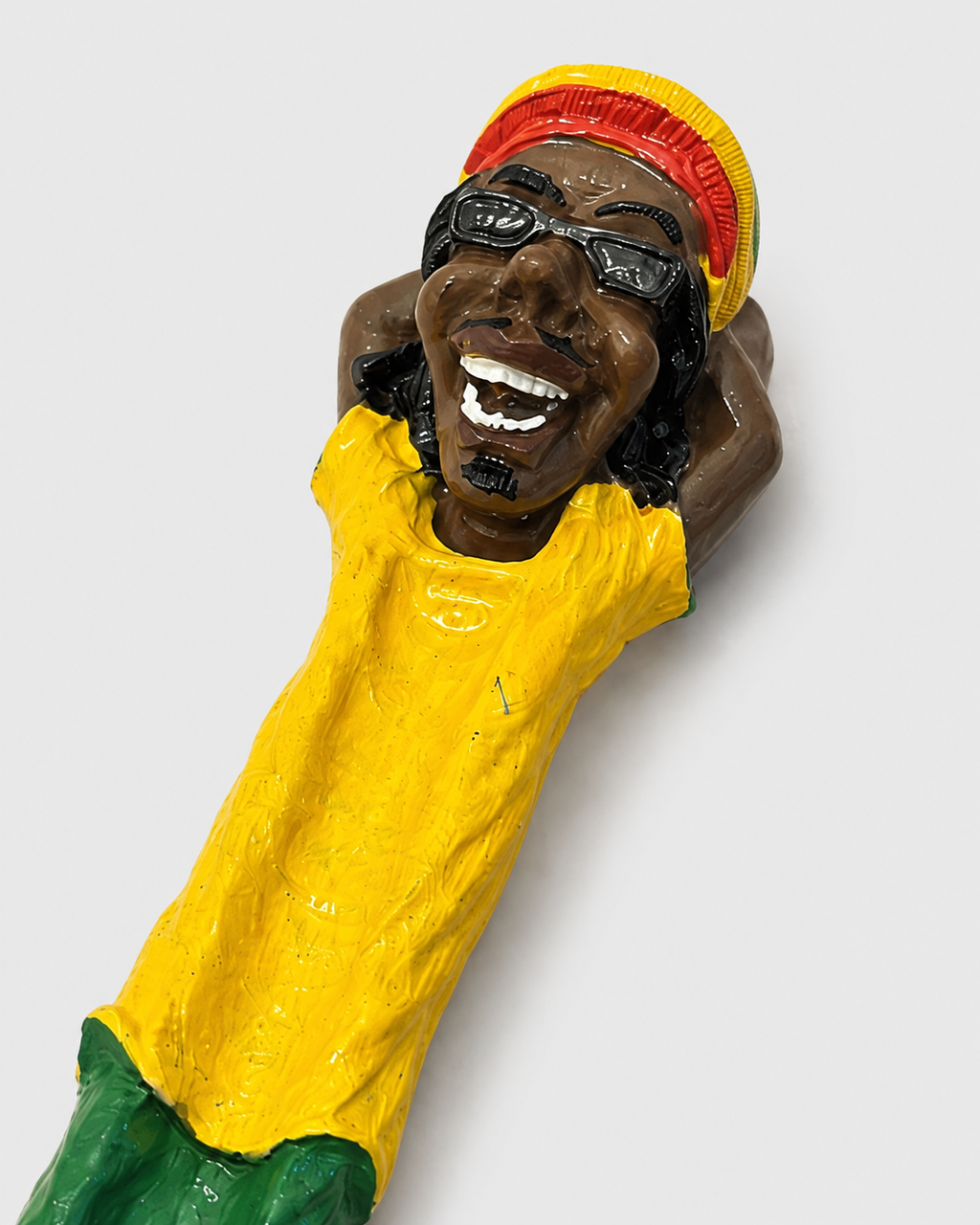 Detalhe do Mystic Breeze: rosto do personagem, com óculos e gorro rasta, e o acabamento da pintura à mão